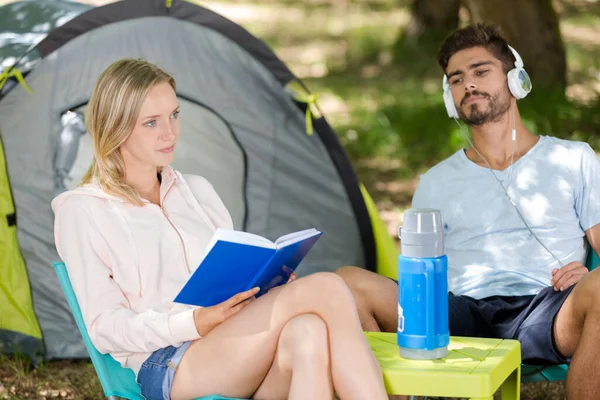 キャンプ中の幸せな若いカップルの読書本 — ストック写真