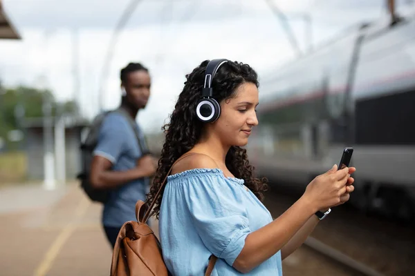 Kvinna Bär Hörlurar Använder Smartphone Medan Väntar Tåget — Stockfoto