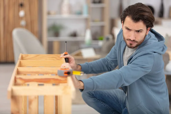 Молодой Человек Измеряет Домашнюю Мебель Помощью Ленты — стоковое фото
