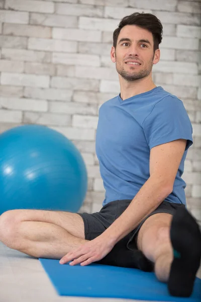 Mann Streckt Bein Auf Yogamatte — Stockfoto