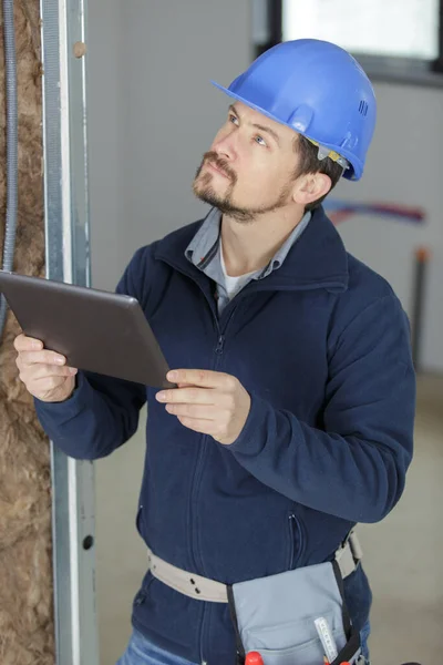 Male Builder Holds Tablet Indoors — Stock Photo, Image