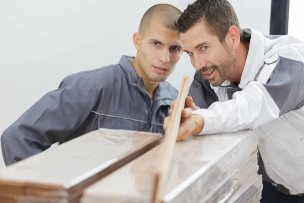 Tischler Mit Lehrling Prüft Holz Gerade Ist — Stockfoto