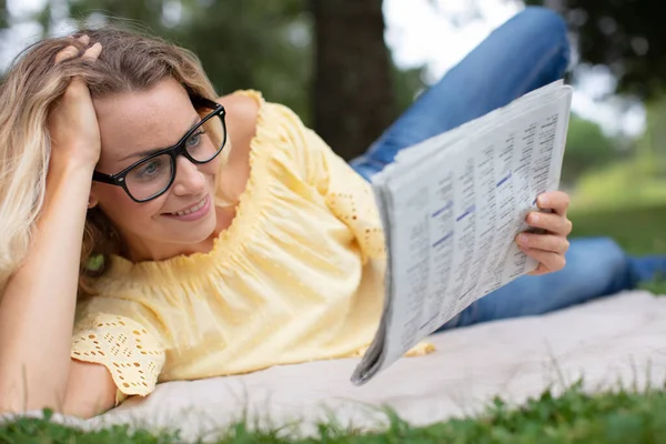 Жінка Лежить Траві Парку Читає Газету — стокове фото