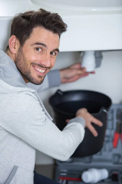 plumber holding a u-bend pipe for a kitchen sink