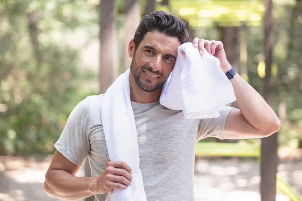 exhausted runner taking a break and wiping his sweat