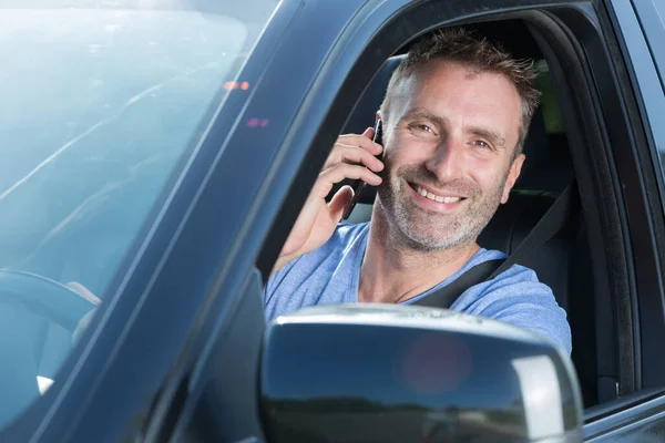 Leende Manlig Förare Som Använder Sin Telefon — Stockfoto