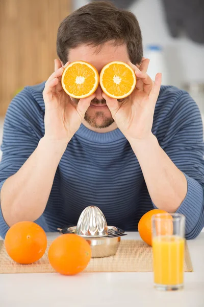 Hombre Sosteniendo Mitades Naranjas Sobre Sus Ojos — Foto de Stock