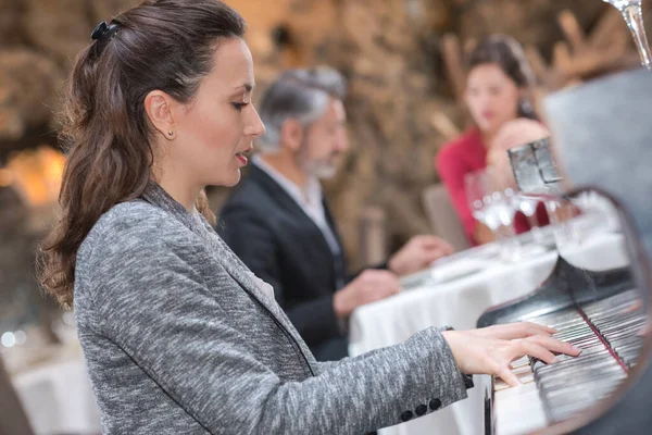 餐馆里的女钢琴家招待客人 — 图库照片