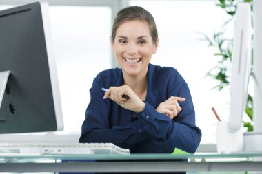 young businesswoman smiling while working at her glass desk clipart