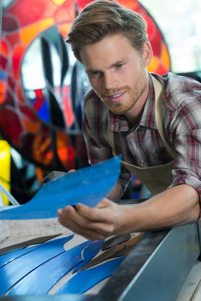 handsome worker near desktop laser engraving machine