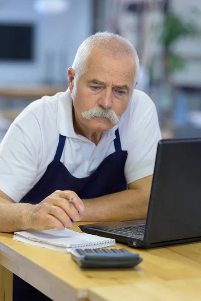 portrait of a senior man writing applications