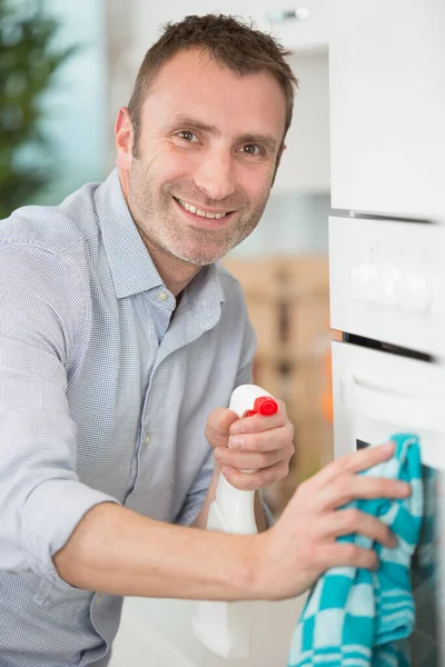 Ευτυχισμένος Άνθρωπος Καθαριστικό Σπρέι Και Πανί Σκούπισμα Κουζίνα — Φωτογραφία Αρχείου