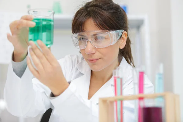 Cientista Fêmea Examinando Líquido Verde Copo — Fotografia de Stock