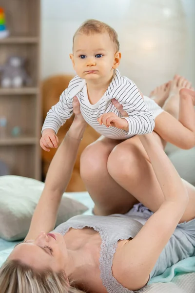 爱玩的女人把孩子抱在膝上 — 图库照片