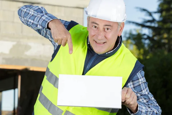 Trabalhador Sorrindo Apontando Para Cartaz Branco — Fotografia de Stock