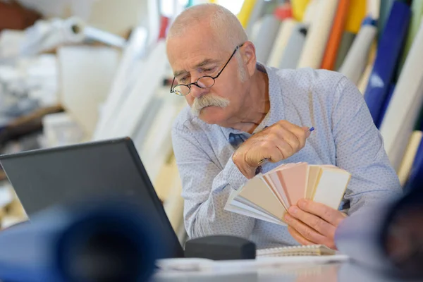 Starszy Mężczyzna Patrząc Próbkę Koloru Laptopie — Zdjęcie stockowe