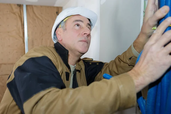 Male Worker Bundling Pipework Interior Building Site — Stock Photo, Image