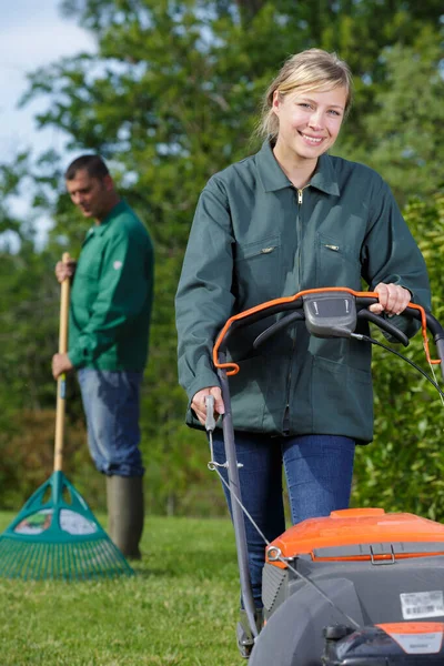 带着割草机的快乐的年轻女人 — 图库照片