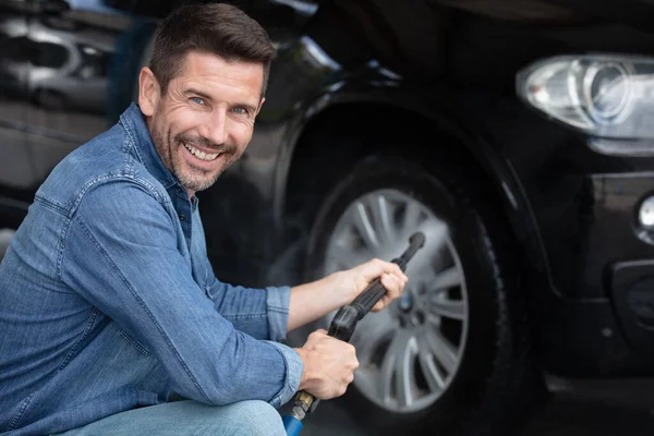 Man Wast Een Wiel Van Een Slang Met Hogedrukwater — Stockfoto