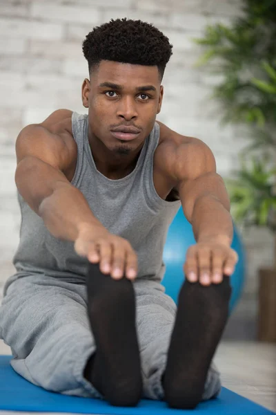 Jovem Homem Esticando Perna Tapete Exercício Casa — Fotografia de Stock