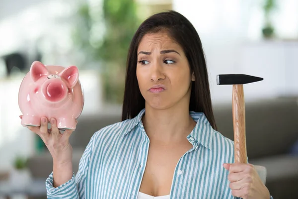 一个女人拿着一个小猪银行和锤子 — 图库照片