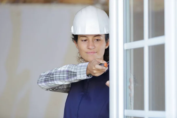 Kvinnlig Arbetare Skruvar Ett Fönster — Stockfoto