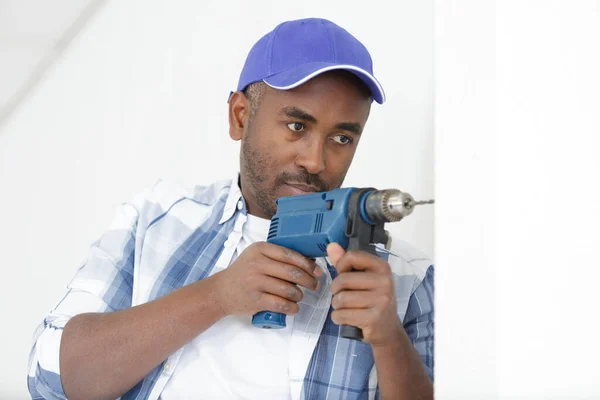 Seriöser Junger Bauhandwerker Arbeitet Mit Elektrobohrmaschine Haus — Stockfoto