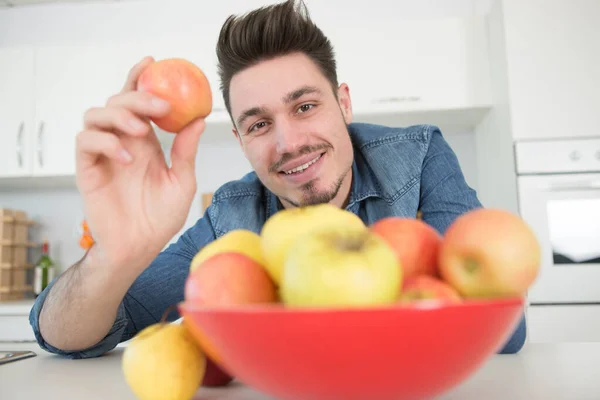 若い男がリンゴを1個食べてる — ストック写真