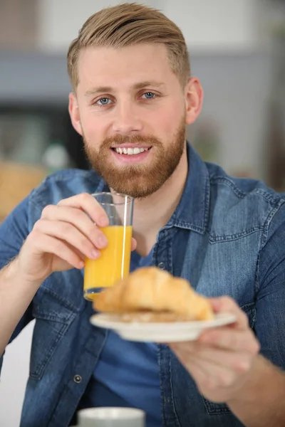 Man Som Håller Ett Glas Juice Och Erbjuder Croissant — Stockfoto