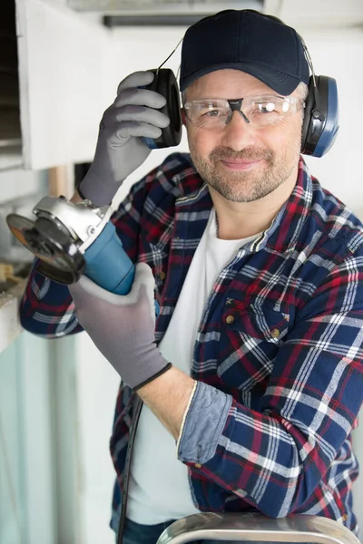 happy carpenter with hearing protection and googles