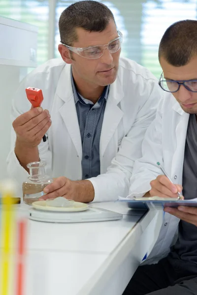 Man Met Klembord Geeft Instructies Aan Jongere Collega — Stockfoto