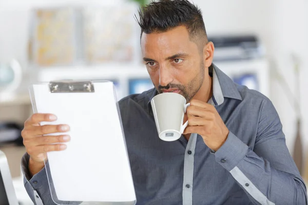 コーヒーを飲みながらノートを持つ男 — ストック写真
