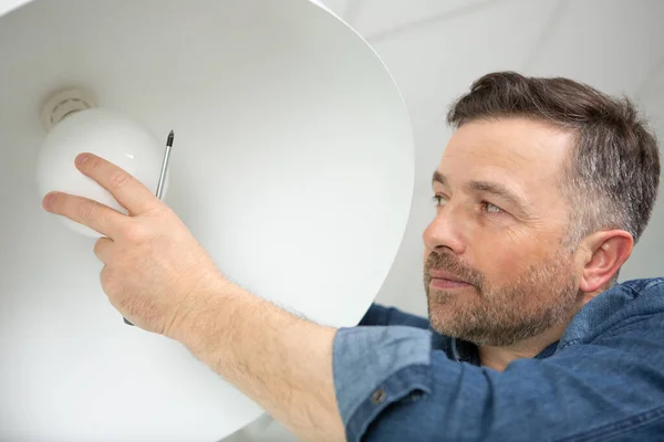 Man Van Veranderende Gloeilamp Hanglamp Binnenshuis — Stockfoto