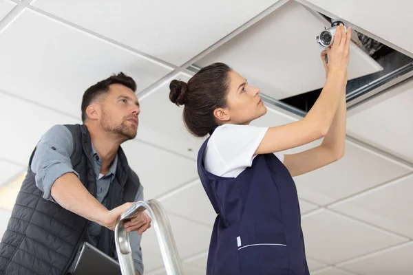 Mannelijke Vrouwelijke Werknemers Inspecteren Plafond Voor Lekken — Stockfoto