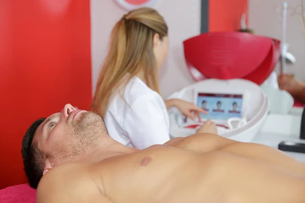 woman waxing mans chest