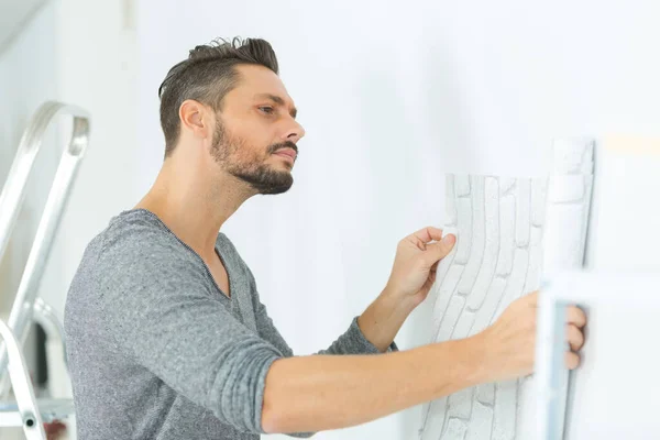 Homem Verificando Planos Contra Parede — Fotografia de Stock