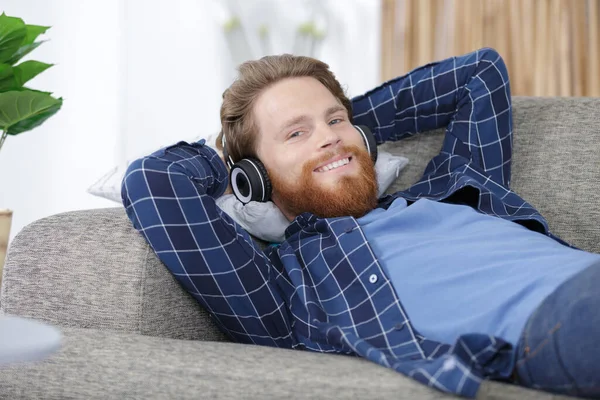 Człowiek Słuchający Muzyki Podczas Relaksu Kanapie — Zdjęcie stockowe