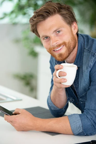 Attraktiv Ung Man Som Använder Mobiltelefon Och Dricker Kaffe — Stockfoto