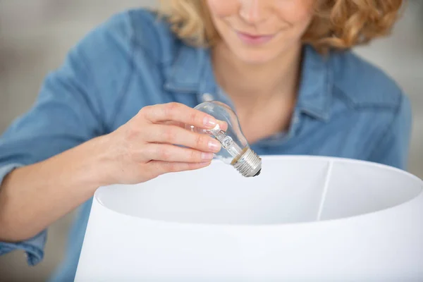 Young Woman Changing Light Bulb — Stock Photo, Image