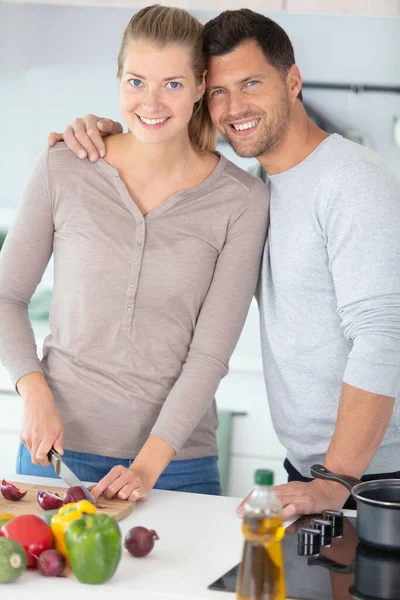 美しい若いカップルが料理をしながら話して笑顔で — ストック写真