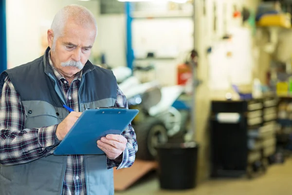 Senior Mechaniker Schreibt Auf Klemmbrett — Stockfoto