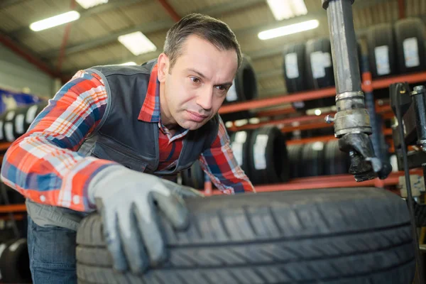 Mandlig Mekaniker Med Bunke Dæk Garage - Stock-foto