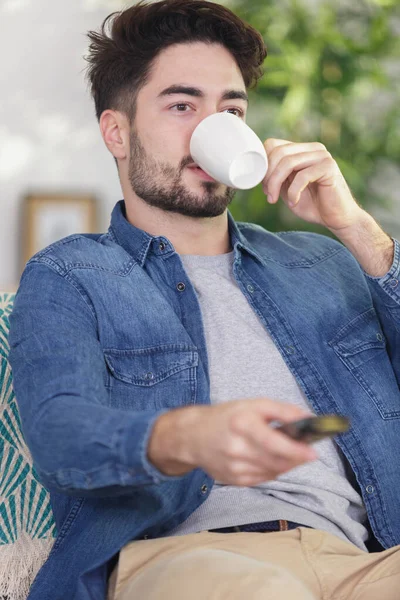 Homme Sirotant Sur Cette Tasse Tenant Télécommande — Photo