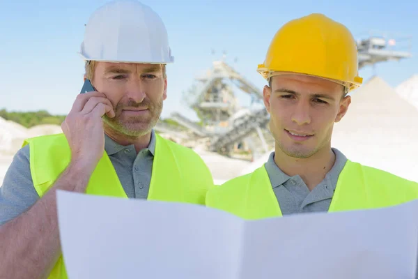 Dois Construtores Canteiro Obras Olhando Para Planos — Fotografia de Stock