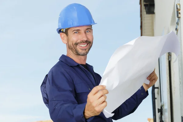 Zufriedener Ingenieur Hält Papier Der Hand Und Lächelt — Stockfoto