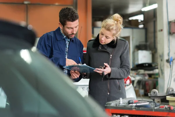 車の修理で女性の顧客とメンテナンスエンジニア — ストック写真