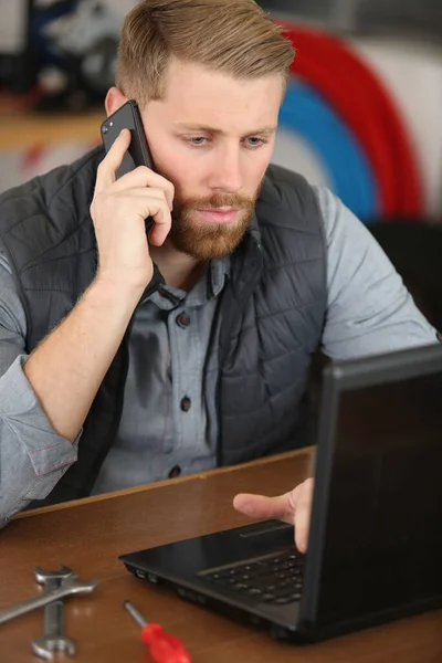 Człowiek Warsztacie Narzędziami Pomocą Laptopa Smartfona — Zdjęcie stockowe