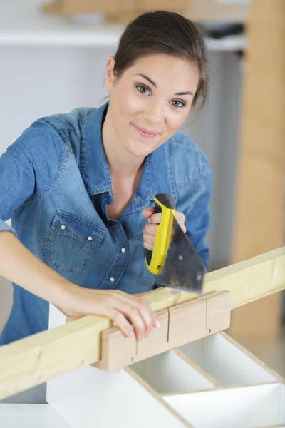 若い女性が木の板を家で切り — ストック写真