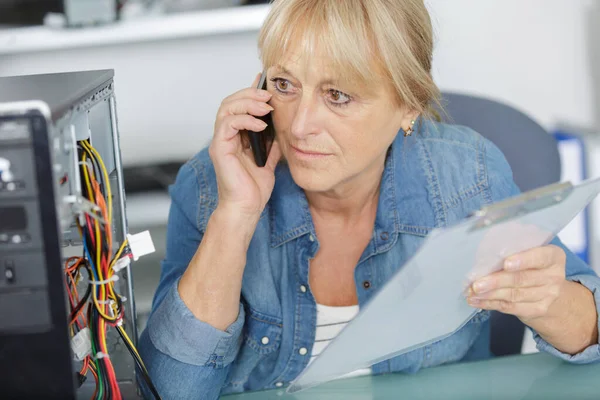 mature female worker on the phone talking to customer