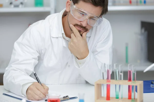 做实验用化学液体在实验室的研究人员 — 图库照片